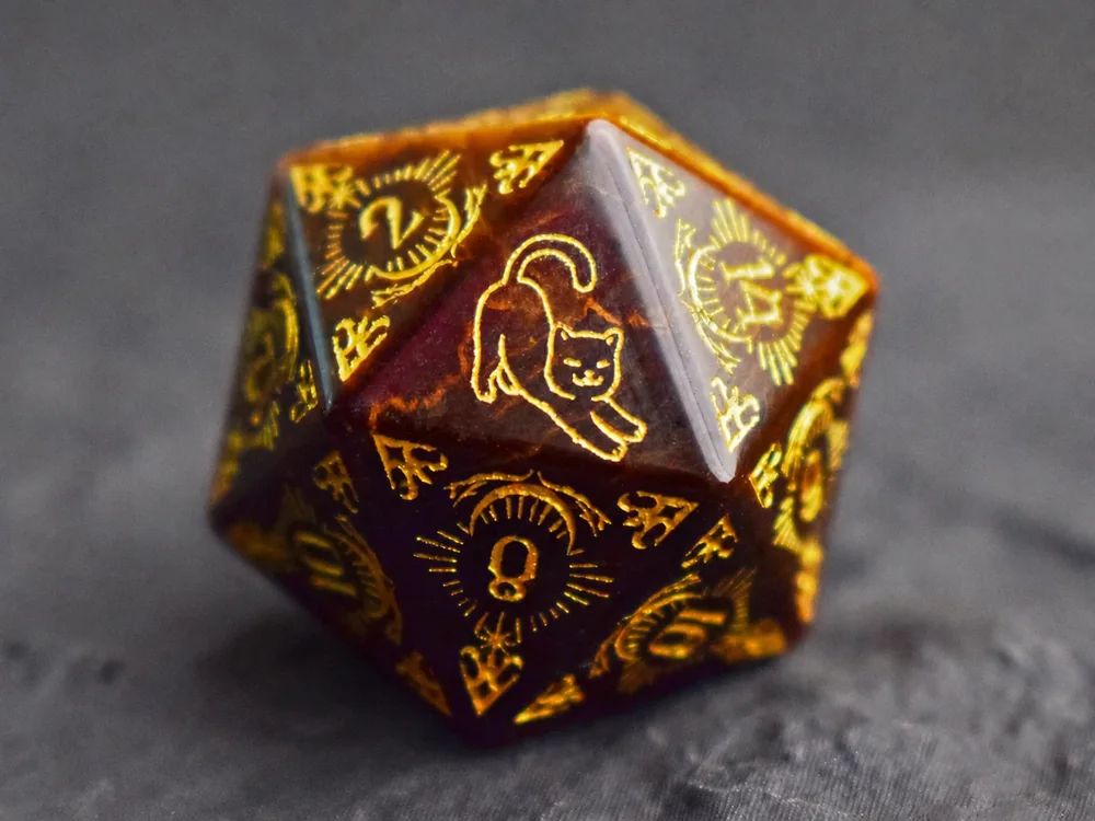 Burgundy D20 with a simple cat design engraved in gold
