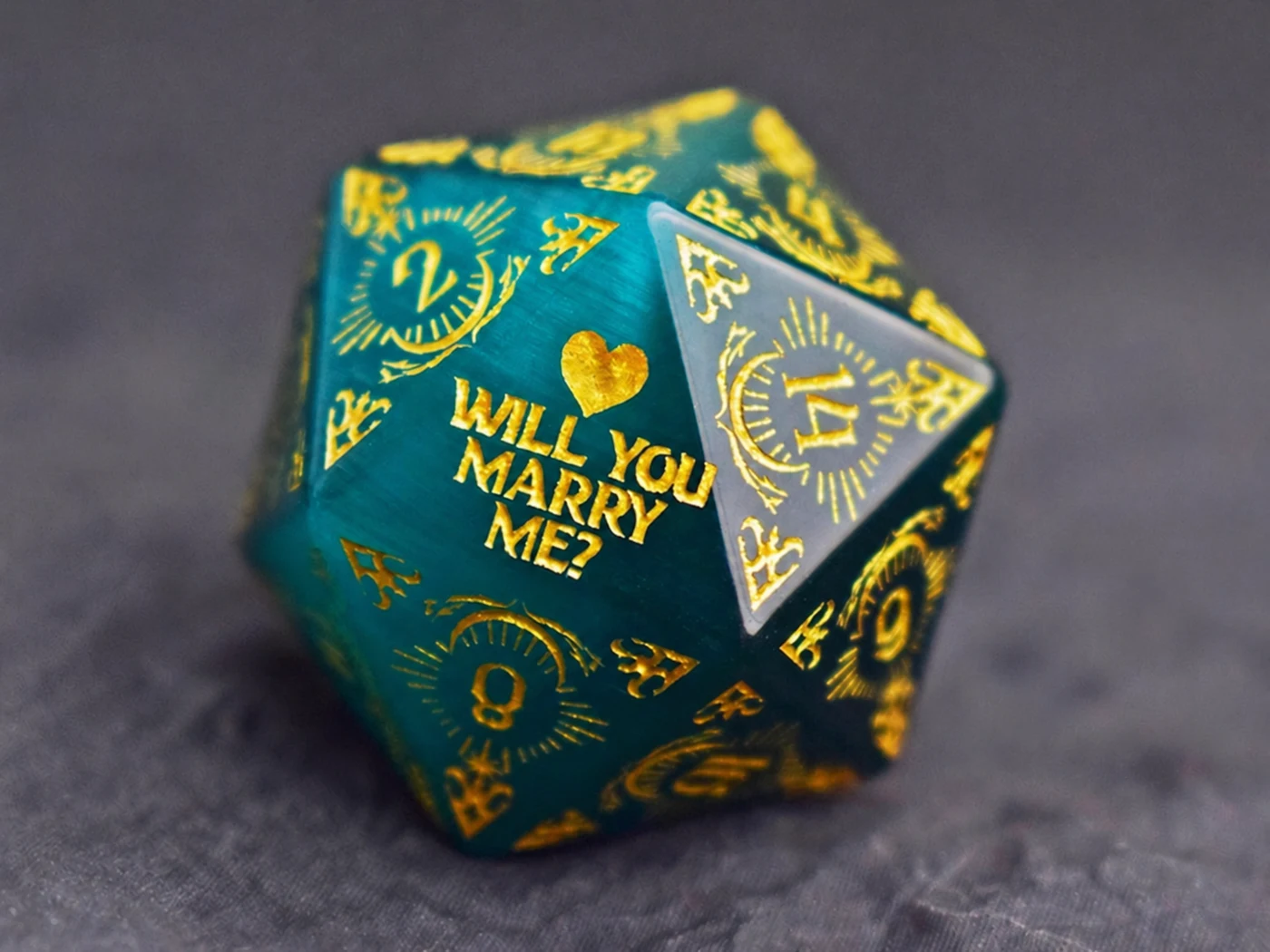 Teal D20 with a gold heart and the words Will you marry me?
