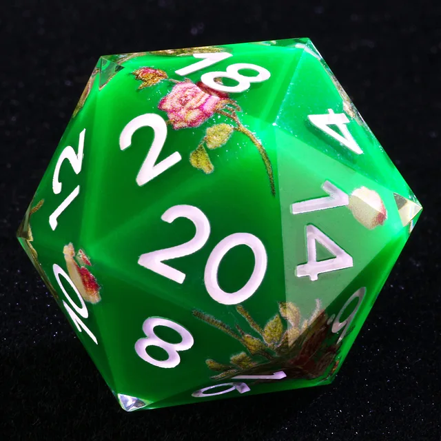 Close-up of a green floral D20 with pale numerals on black fabric.