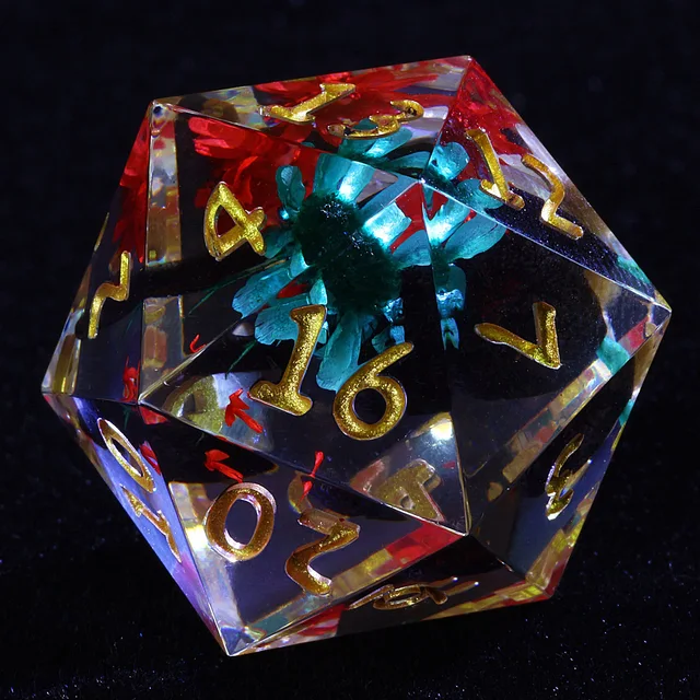 Close-up of a clear D20 with gold numbers and turquoise and red flowers inside.