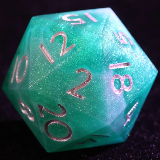 Close-up of a turquoise and green swirled glitter D20 with metallic numbers.