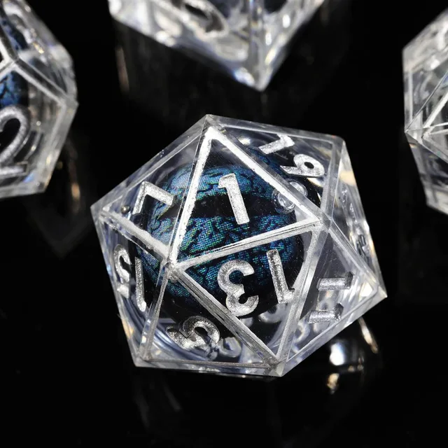 Close-up of a clear D20 with silver numbers and a blue-black patterned core.