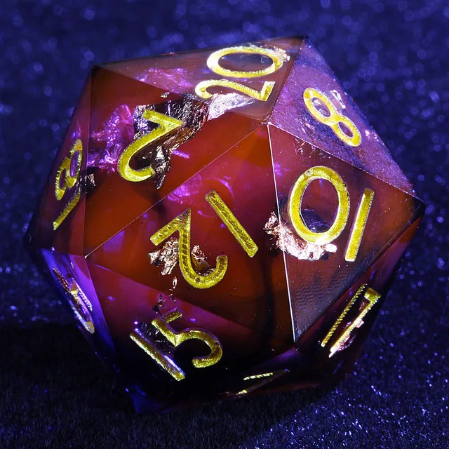 Close-up of a dark red and black D20 with gold-coloured numbers and metallic flakes.