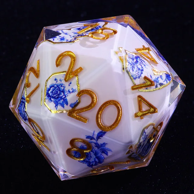 Close-up of a white and blue floral D20 with gold numerals and clear edges.
