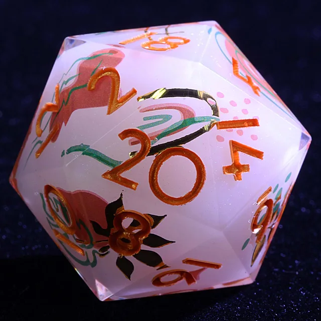 Close-up of a pale lavender-white D20 with pink and teal botanical patterns and metallic orange numbers.