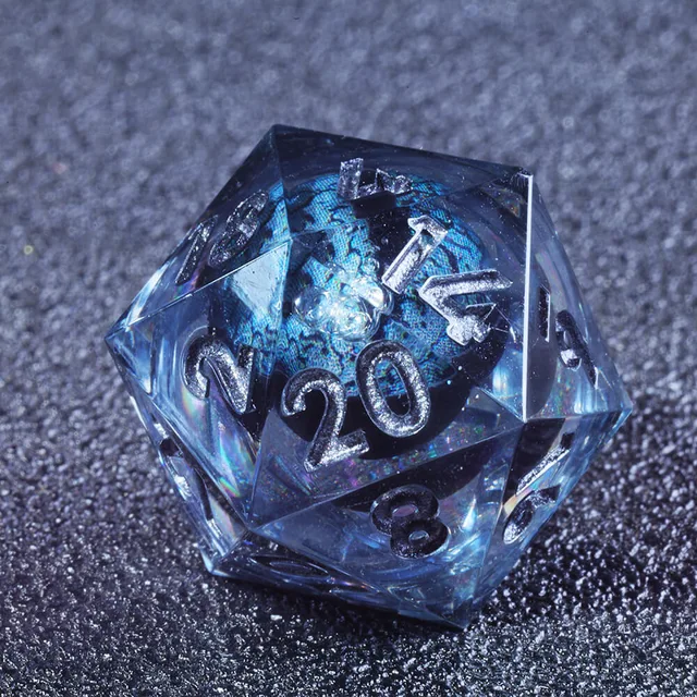 Close-up of a smoky blue D20 with silver numbers and a blue-iridescent eye-like centre.