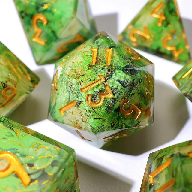 Close-up of a green floral D20 with gold numbers.
