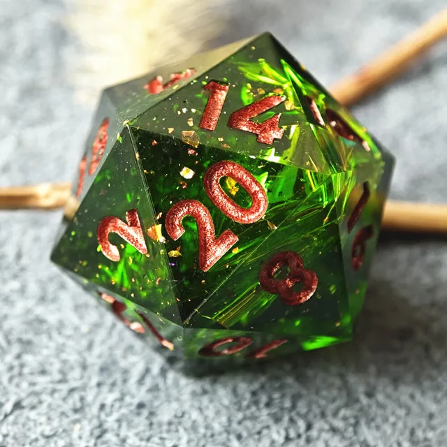 Close-up of a green D20 with copper-red numbers beside branches.