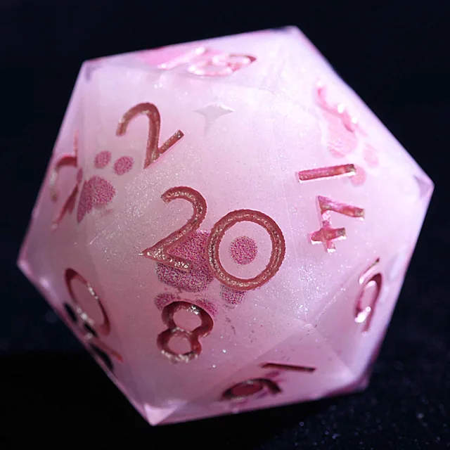Close-up of a shimmering pale pink D20 with metallic pink numbers and a pink paw print.