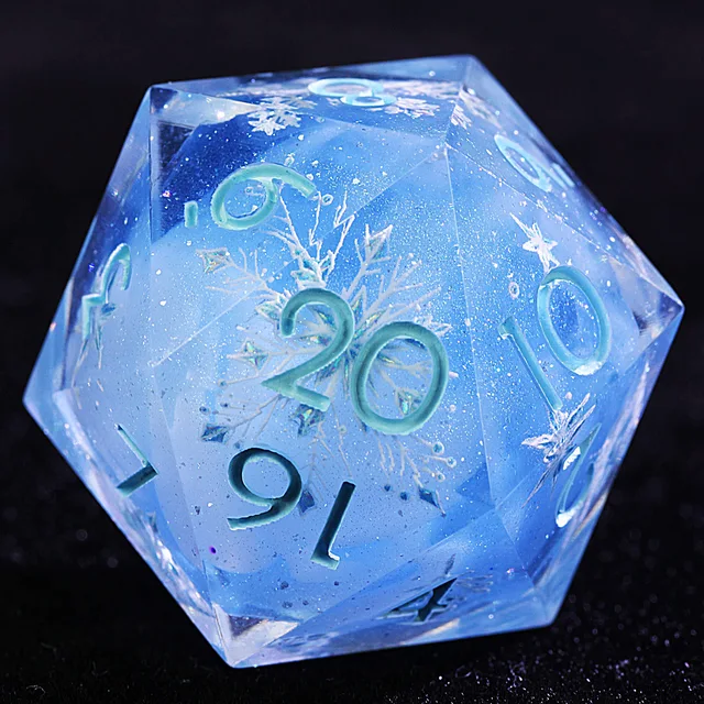 Close-up of a translucent blue D20 with a white snowflake pattern, glitter and pale turquoise numbers.