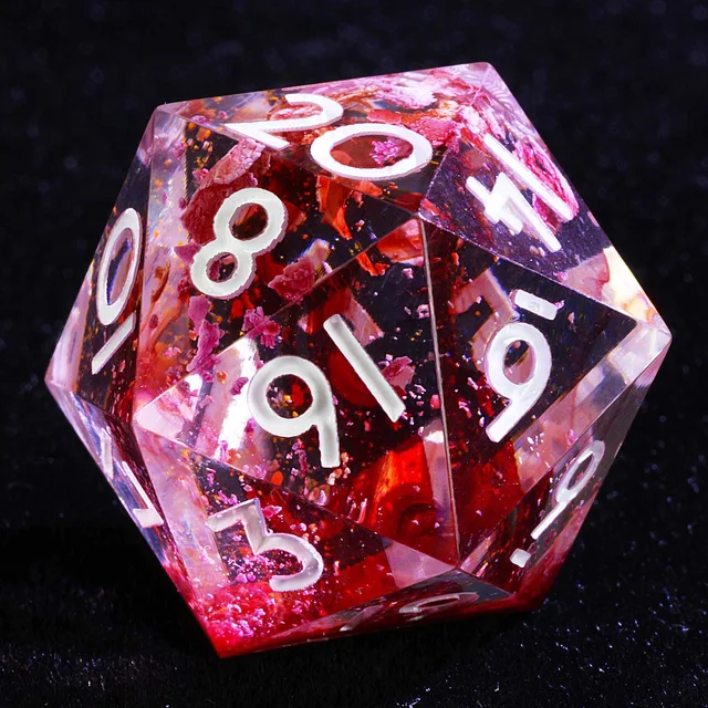 Close-up of a translucent red D20 with pink inclusions and white numbers.