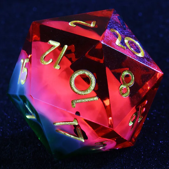 Close-up of a watermelon-coloured D20 with gold numerals.