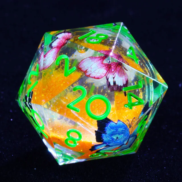 Close-up of clear D20 with green numbers, orange core, and colourful butterflies.