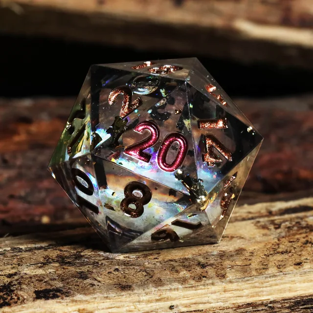 Close-up of a smoky liquid-core D20 with red and copper numbers on wood.