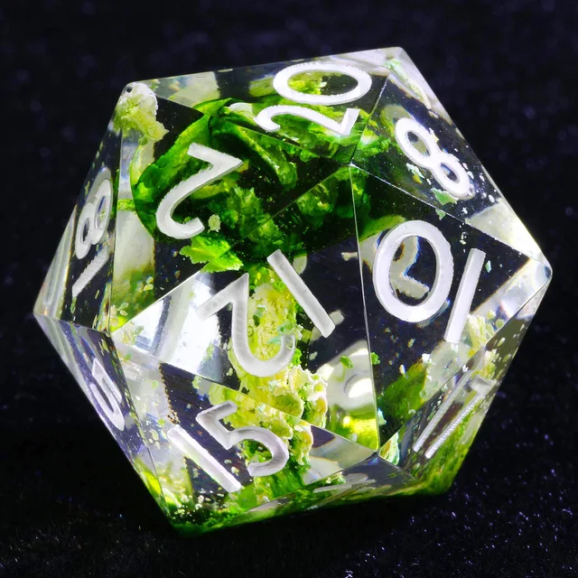 Close-up of a clear D20 with green inclusions and white numerals.