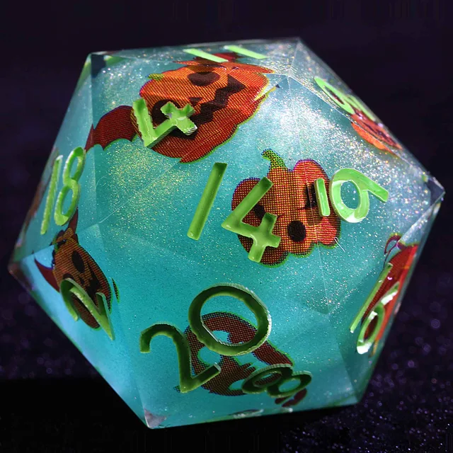 Close-up of a teal-green glitter D20 with green numerals and orange pumpkin faces.