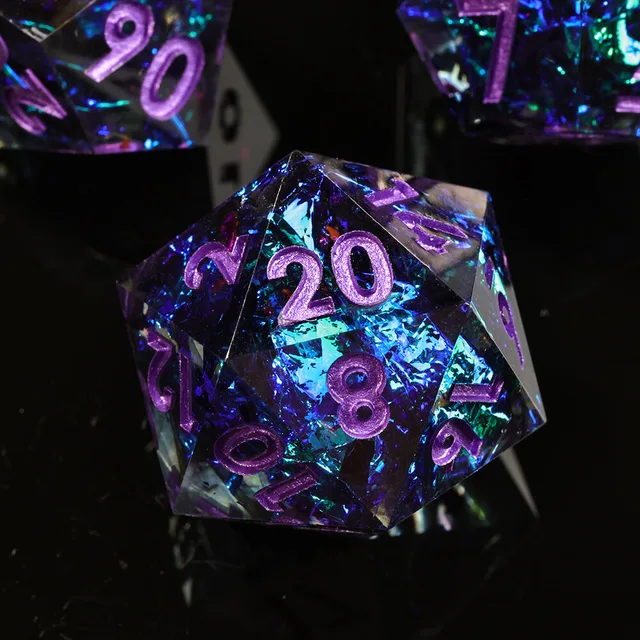 Close-up of a blue-purple glittering D20 with metallic purple numbers.