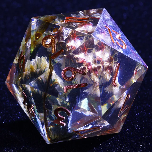 Close-up of a clear floral D20 with copper-coloured numbers.