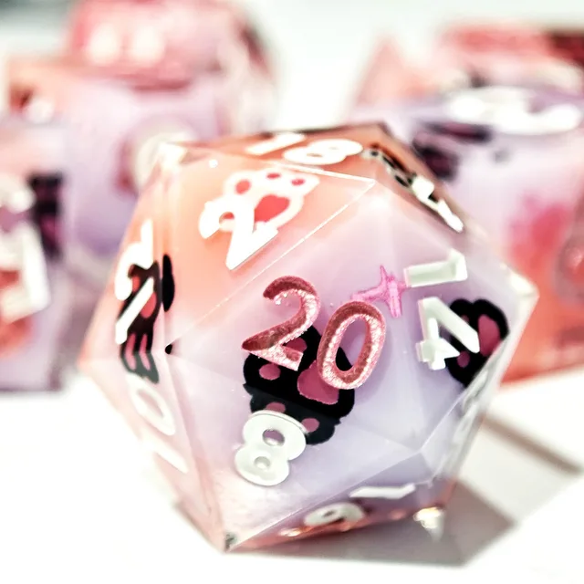 Close-up of a pink and lavender paw-print D20.