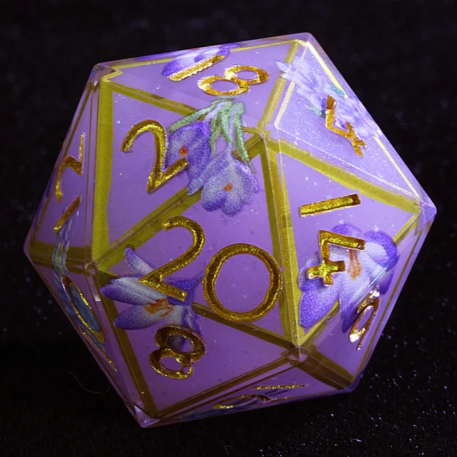 Close-up of a lavender D20 with gold numbers and purple flowers.