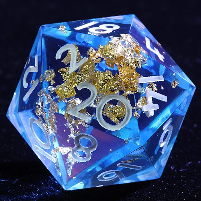 Close-up of a transparent blue D20 with gold-coloured inclusions and white numerals.