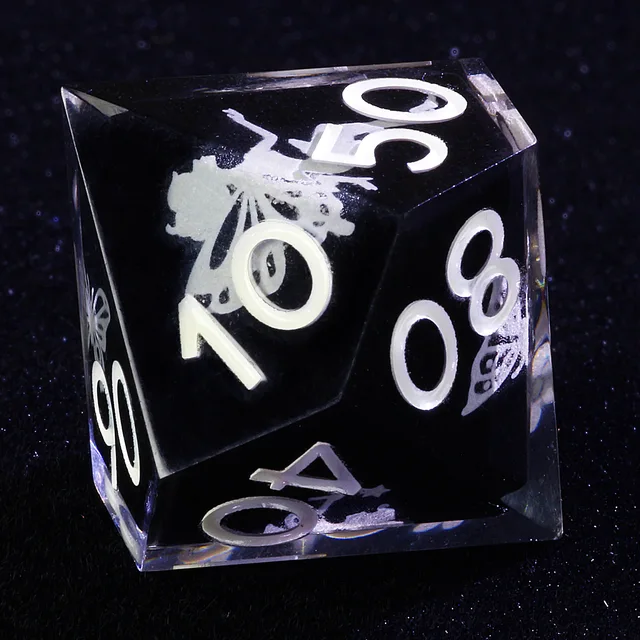 Close-up of clear percentile die with pale numerals and butterfly illustrations
