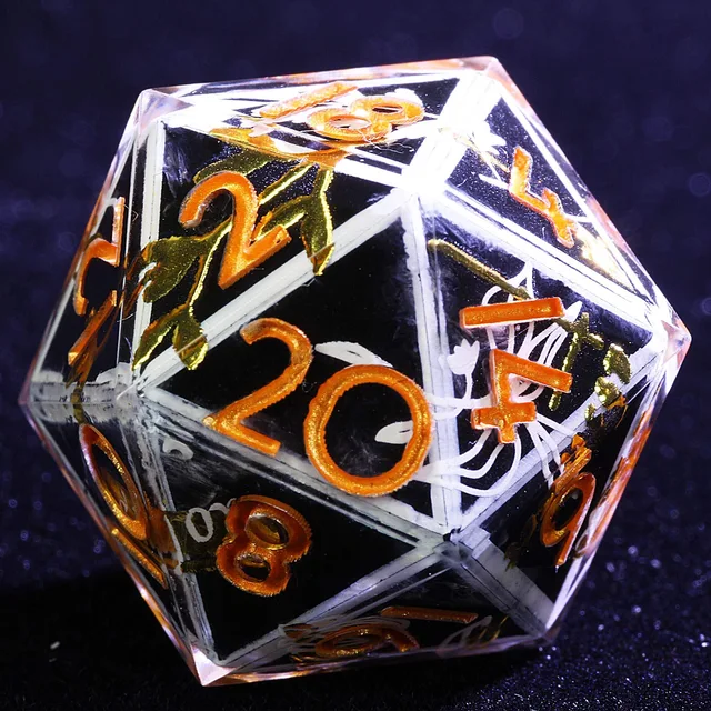 Close-up of a clear D20 with a dark centre, white floral lines, gold details, and orange numbers.