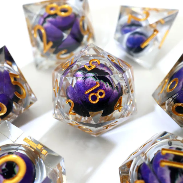 Close-up of a clear D20 with a purple eye-like core and gold numbers