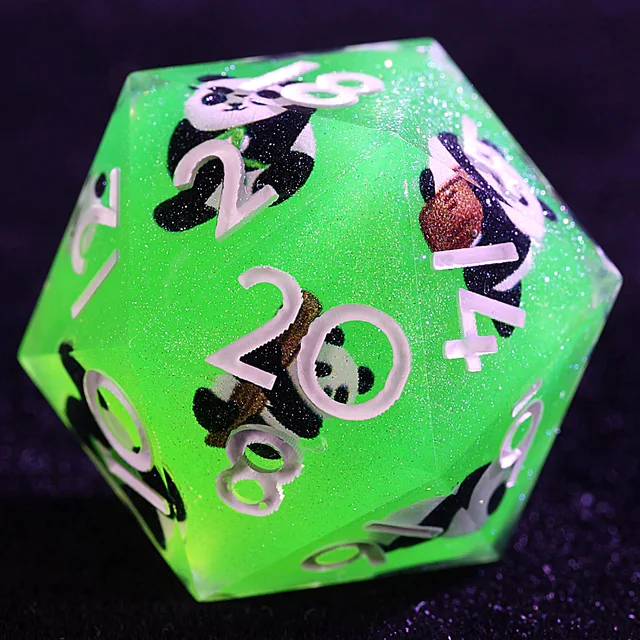 Close-up of a green glitter D20 with pale numbers and panda figures inside.