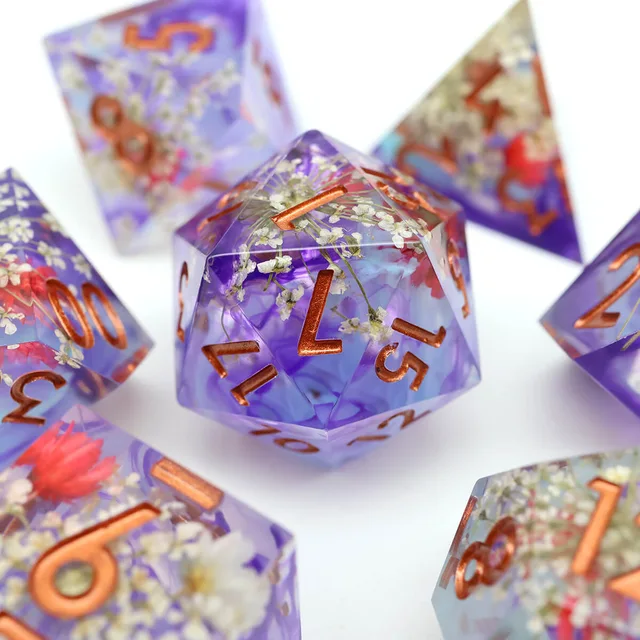 Close-up of a violet floral D20 with copper-coloured numbers.