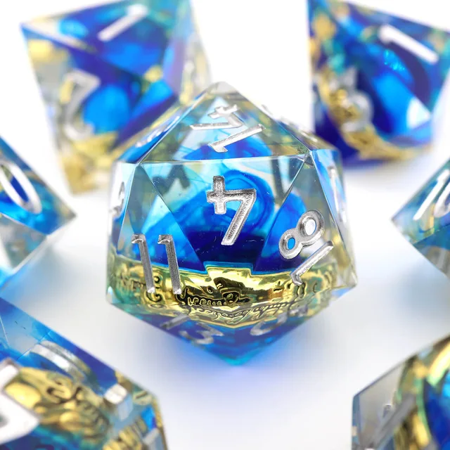 Close-up of a blue twenty-sided die with a gold ring inclusion and silver numbers.