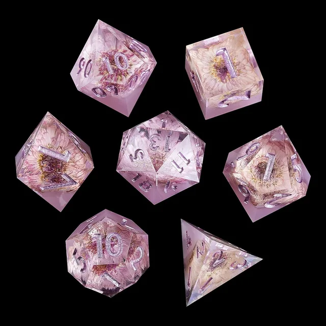 Complete set of seven translucent pale pink floral dice on black.
