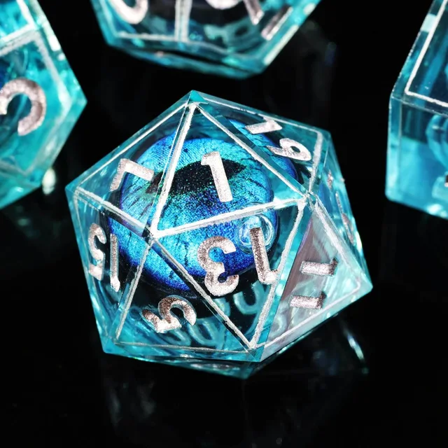 Close-up of an aqua-blue D20 with silver numbers and a blue eye-like core.
