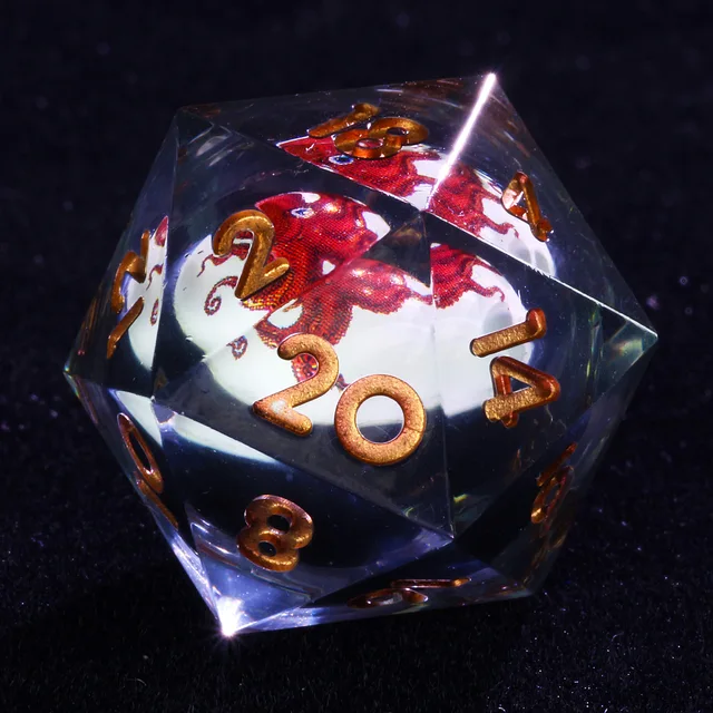 Close-up of a clear D20 with gold numbers and a red octopus design.