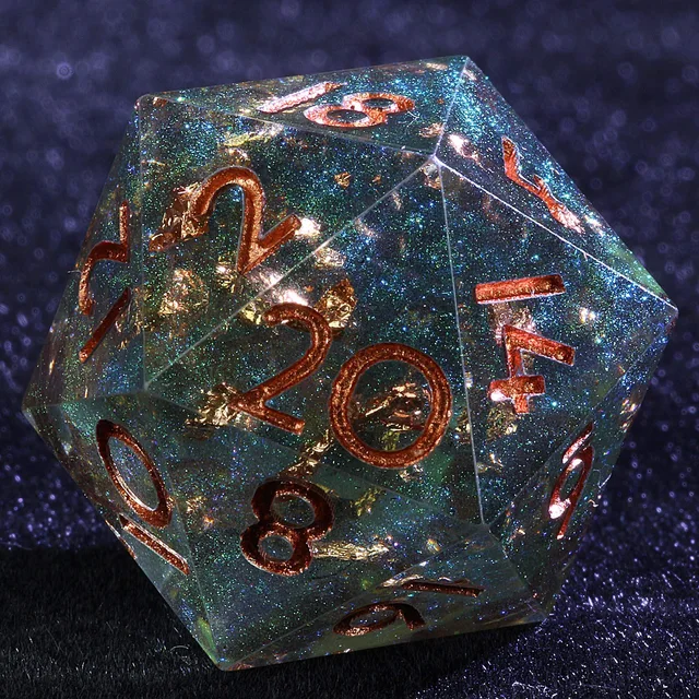 Close-up of a teal-green glittering D20 with gold inclusions and copper-gold numerals.