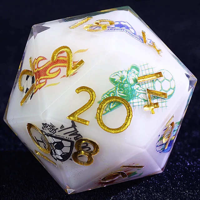 Close-up of a white D20 with glittering gold numbers and colourful soccer graphics.