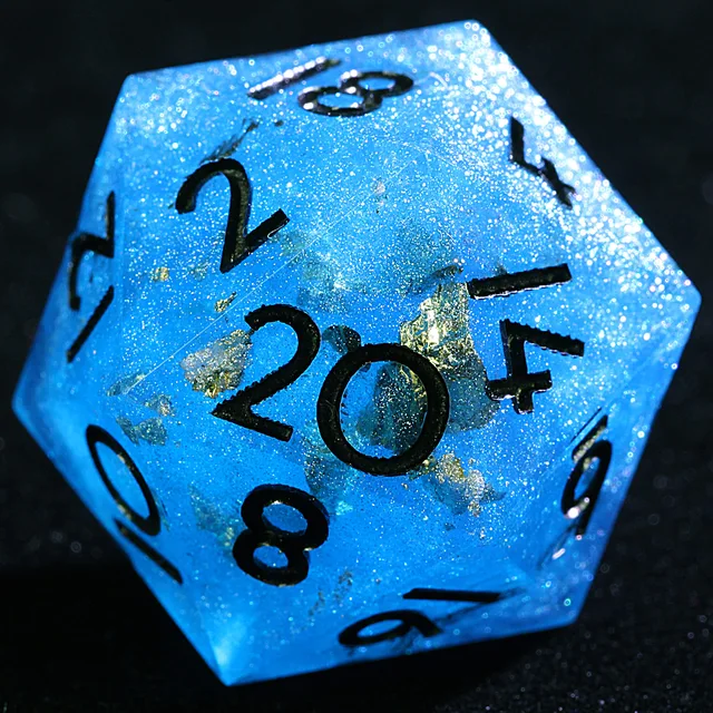 Close-up of a blue glittering D20 with gold-coloured flecks and black numbers.