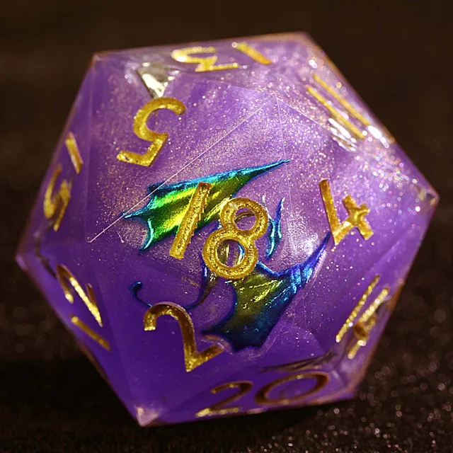 Close-up of a purple glitter D20 with gold numbers and blue-green wing details.
