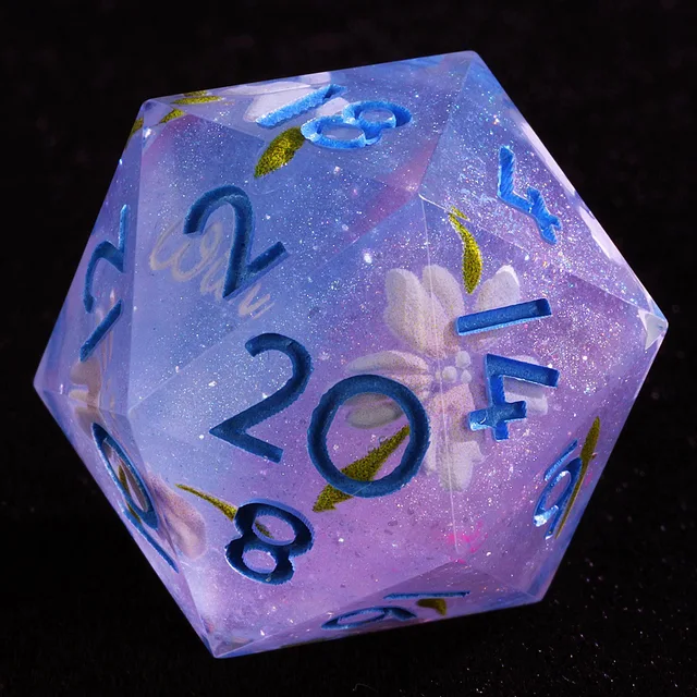 Close-up of a lavender and blue D20 with blue numerals, sparkle and white flowers.