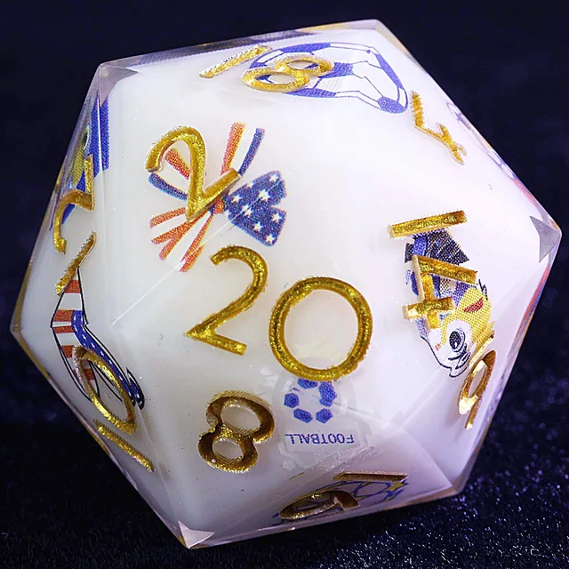 Close-up of a white D20 with glittering gold numbers and blue and red soccer-themed graphics.
