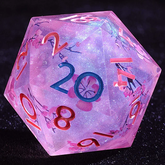 Close-up of a pink and lavender glittering D20 with cherry blossoms and blue and red numerals.