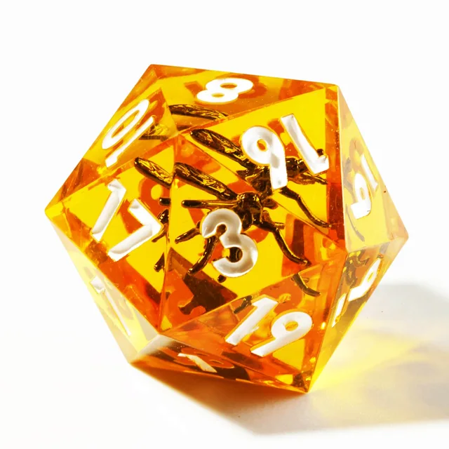 Close-up of an amber-orange twenty-sided die with white numbers and dark insect-shaped inclusions.