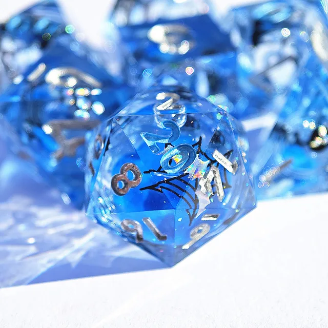 Close-up of a transparent blue D20 with silver numbers and a black cat silhouette.