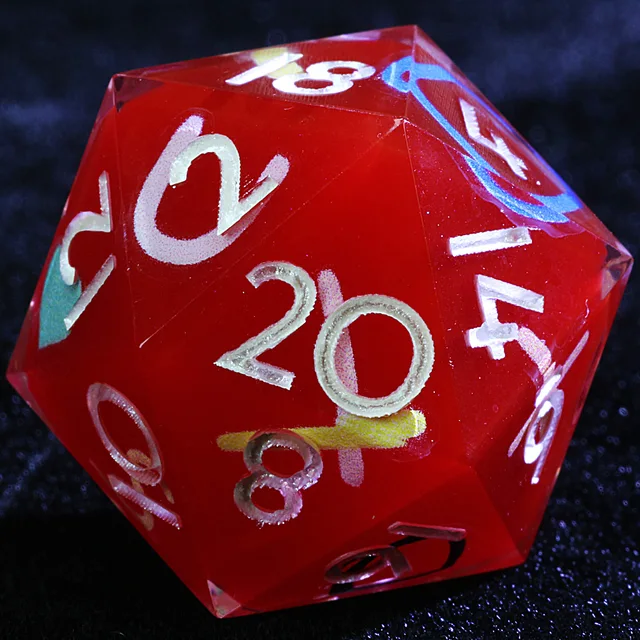 Close-up of red D20 with pale numerals and colourful candy-like markings