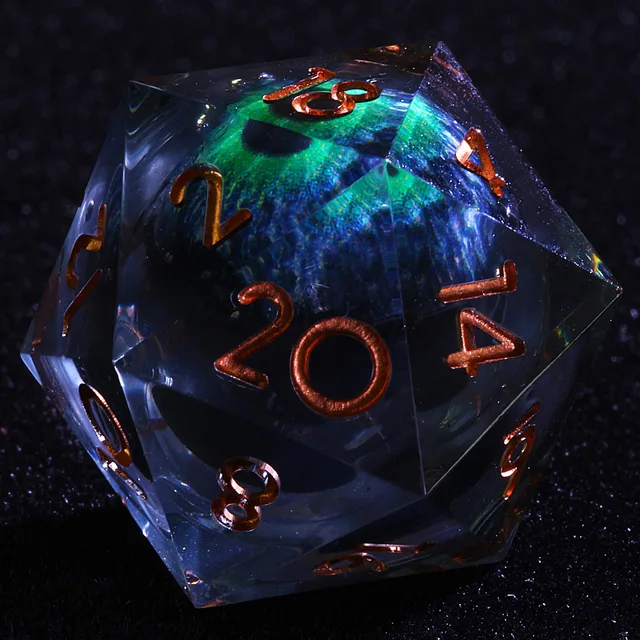 Close-up of a clear D20 with a blue-green eye-like core and copper-coloured numbers.