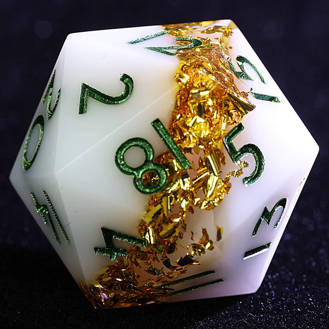 Close-up of a white polyhedral die with a gold-foil band and green numerals.