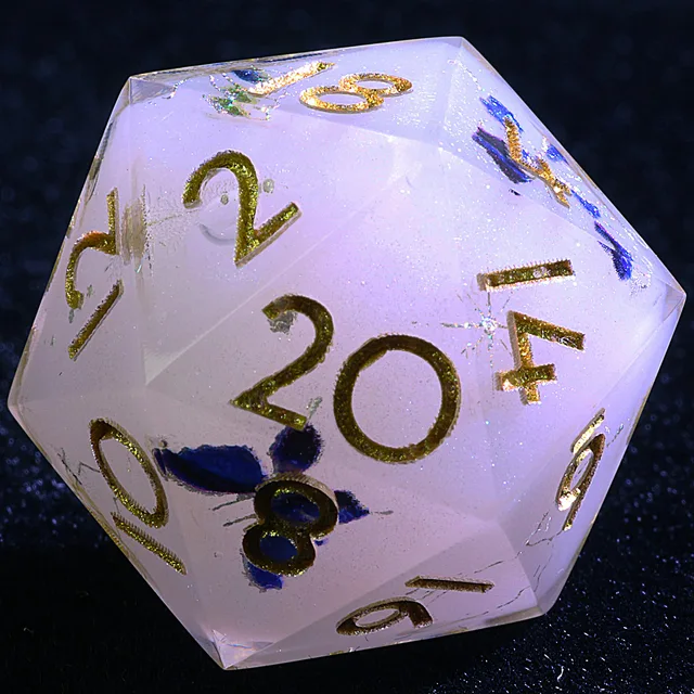 Close-up of a pale translucent D20 with gold numbers and blue-purple butterfly-like inclusions.