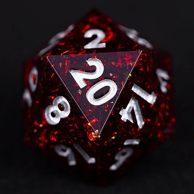 Close-up of a red D20 showing silver-coloured numbers and sparkling flakes.
