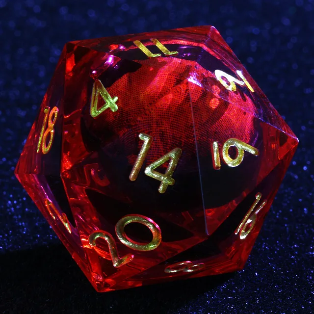 Close-up of a transparent red D20 with gold-coloured numbers and an eye-like core.