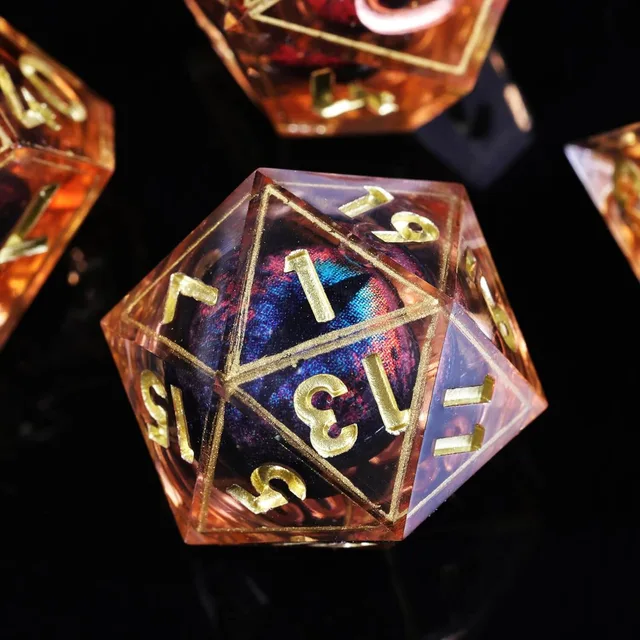 Close-up of an orange D20 with gold numbers and a blue-red eye-like core.